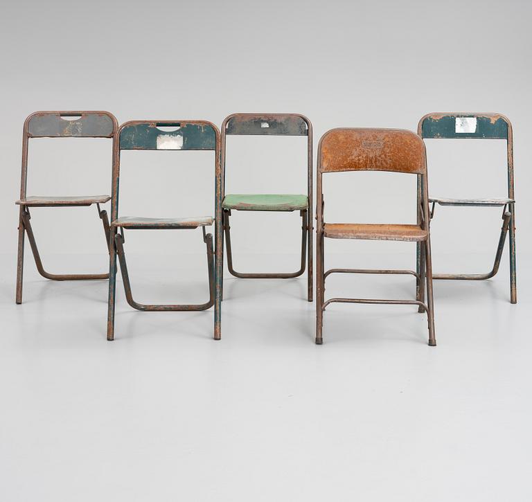 A set of five folding chairs.