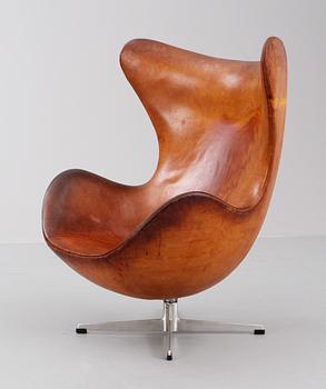 An Arne Jacobsen brown leather 'Egg chair' with ottoman, by Fritz Hansen, Denmark 1963.