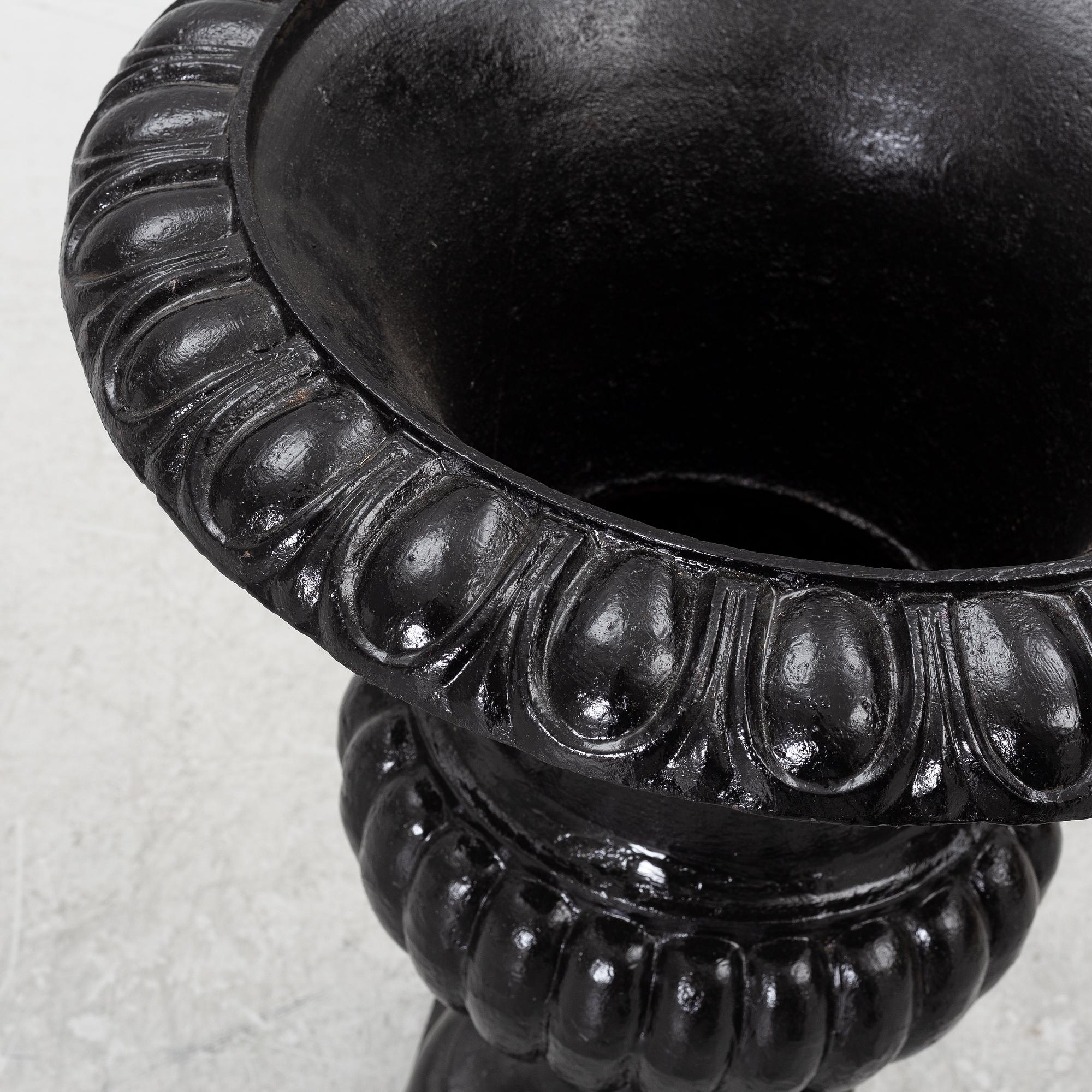 A pair of cast iron garden urns, 20th century.