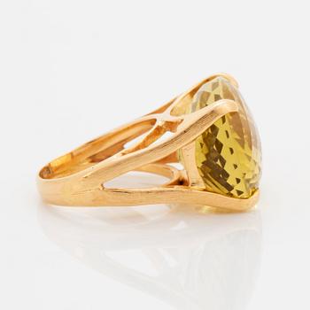 An 18K gold ring set with a faceted lemon quartz.