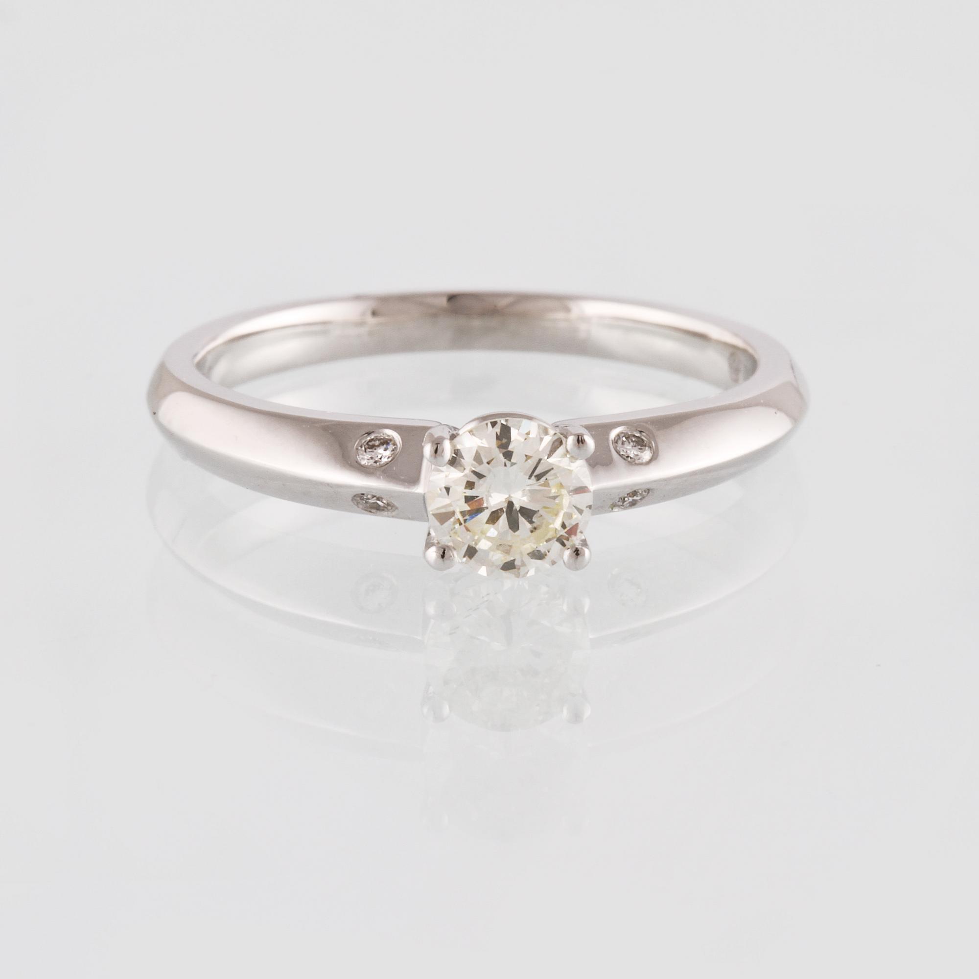 RING, 18K vitguld med briljantslipad diamant 0.47 ct samt 4 små briljantslipade diamanter 0.03 ct. Vikt 3,0 gram.