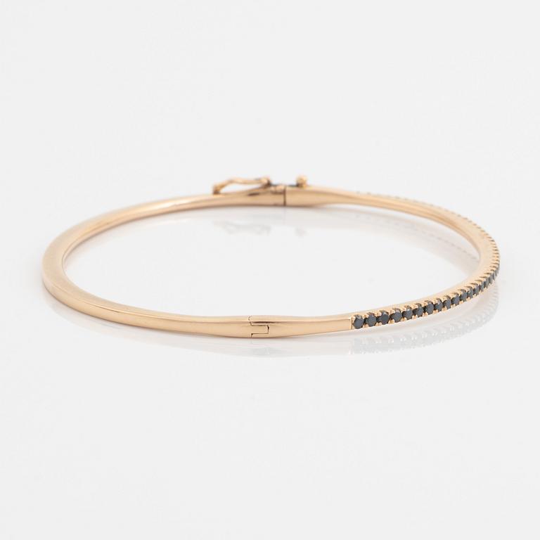 An 18K rose gold bangle set with round brilliant-cut black diamonds.