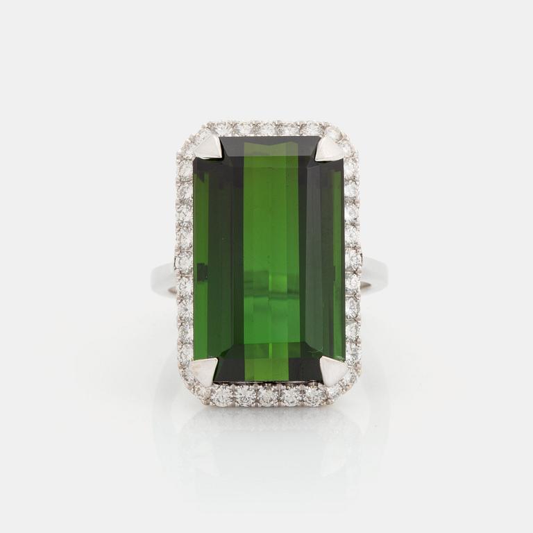 An 18K white gold ring set with a step-cut green tourmaline and round brilliant-cut diamonds.