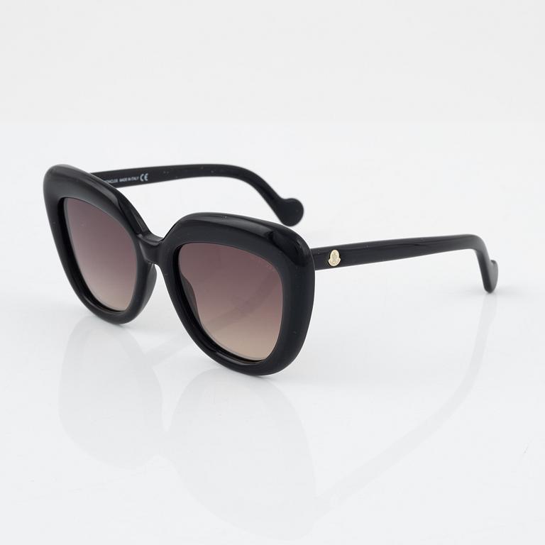 Moncler, a pair of black plastic sunglasses.