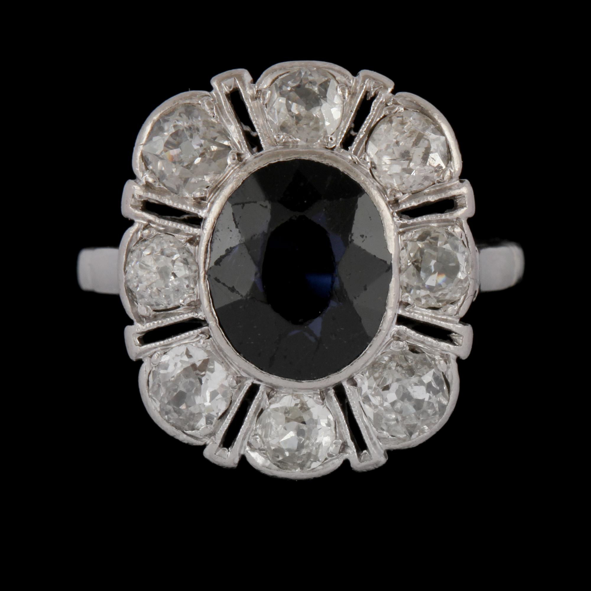 RING, platina med äldre briljantslipade diamanter samt ovalslipad blå safir, 1900-talets början. Vikt.