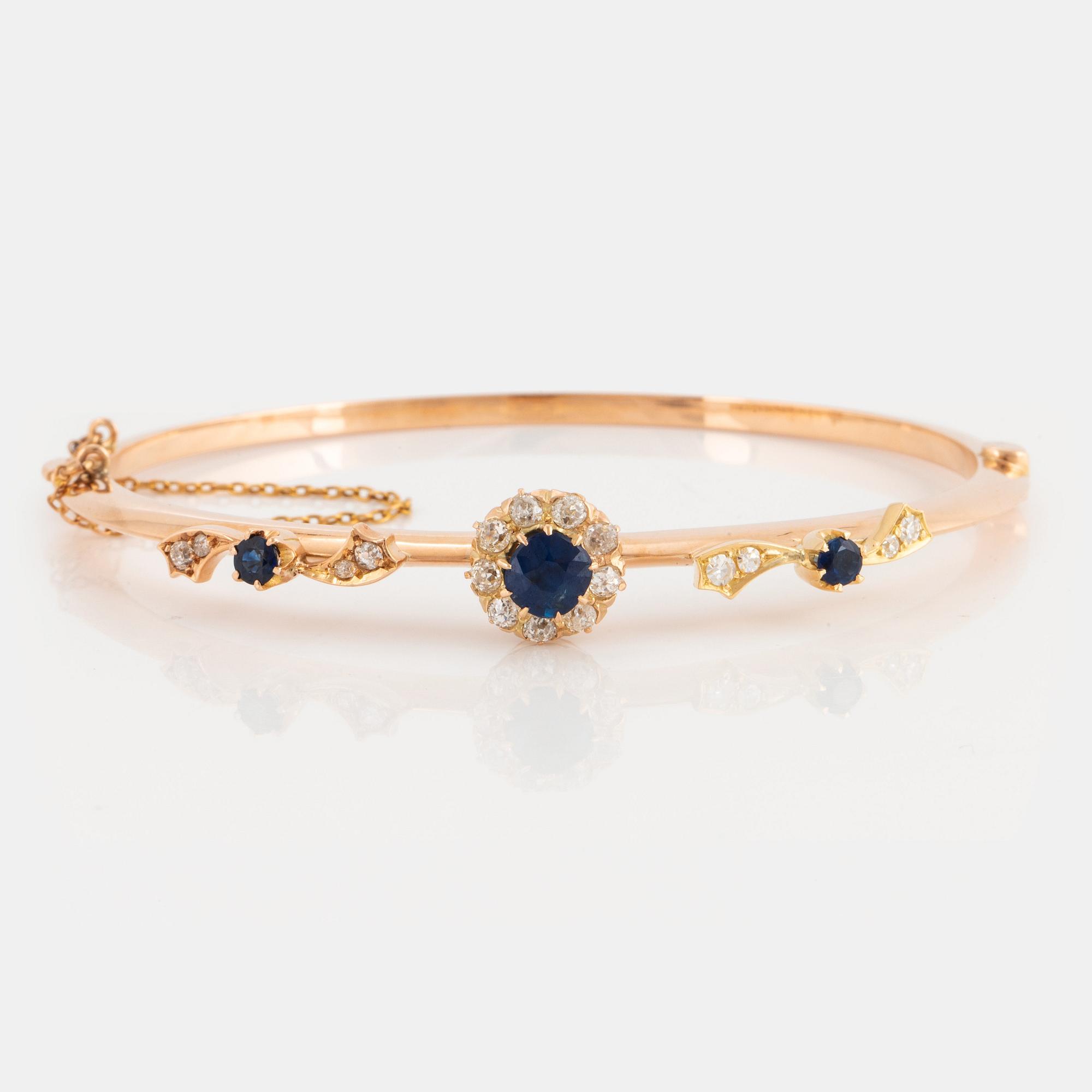 An 18K gold bangle set with faceted sapphires and old-cut diamonds.