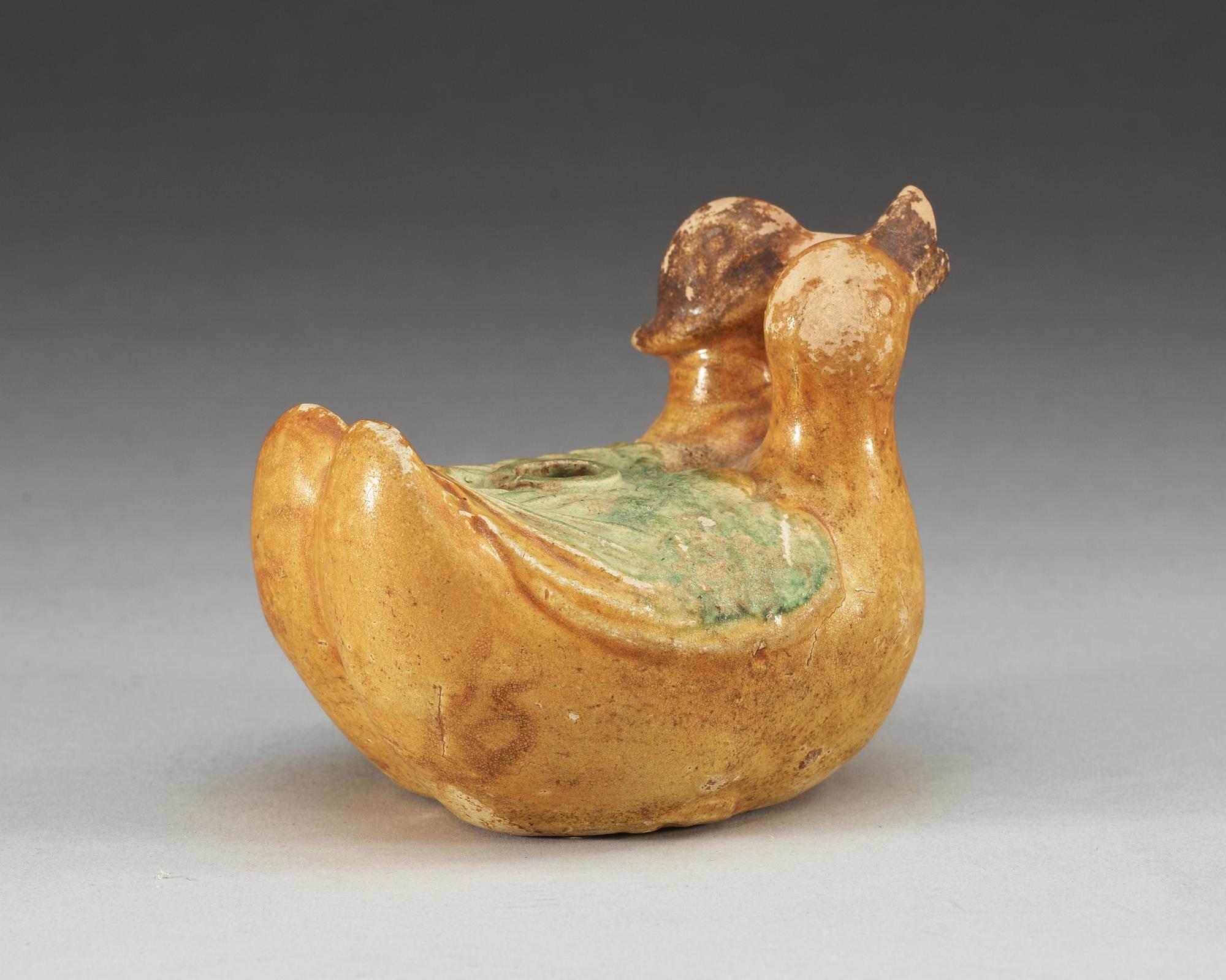 A yellow and green glazed figurine of two mandarin ducks. Ming dynasty ( 1368-1644).