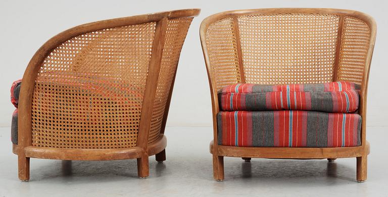 A pair of Oscar Nilsson beech and rattan arm chairs.
