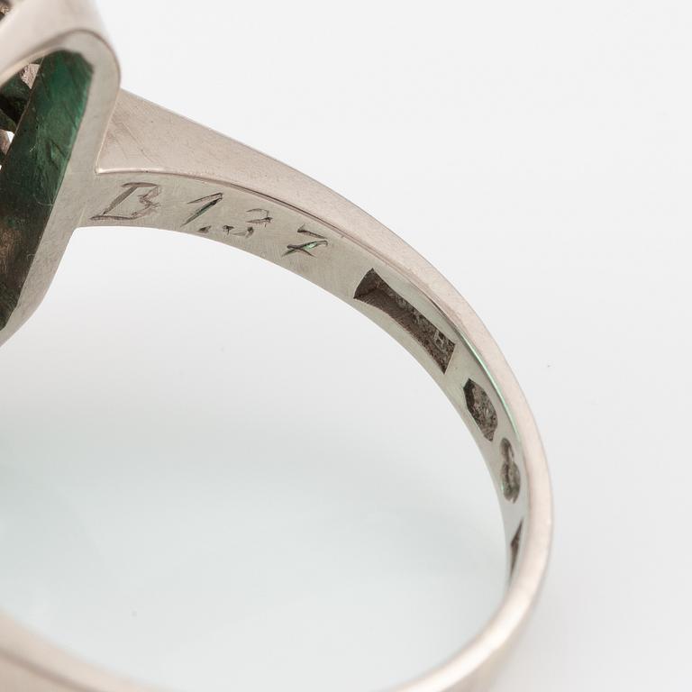 Ring 18K vitguld med en fasettslipad smaragd och runda briljantslipade diamanter.