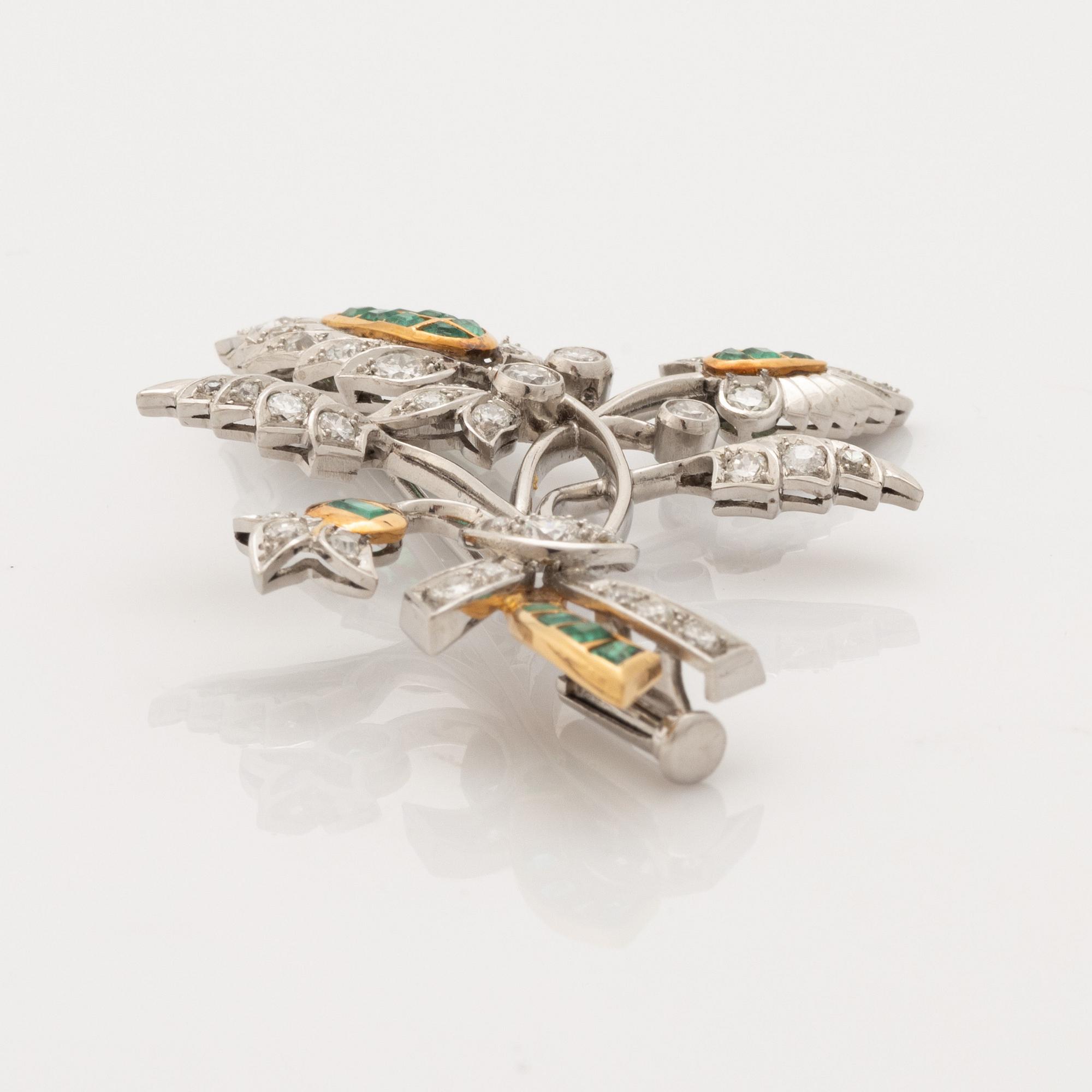 Platinum and gold with brilliant cut diamonds and emerald brooch.