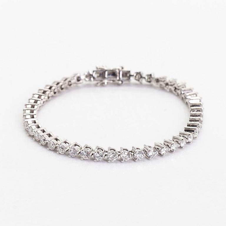 An 18K white gold tennis bracelet, with brilliant-cut diamonds.