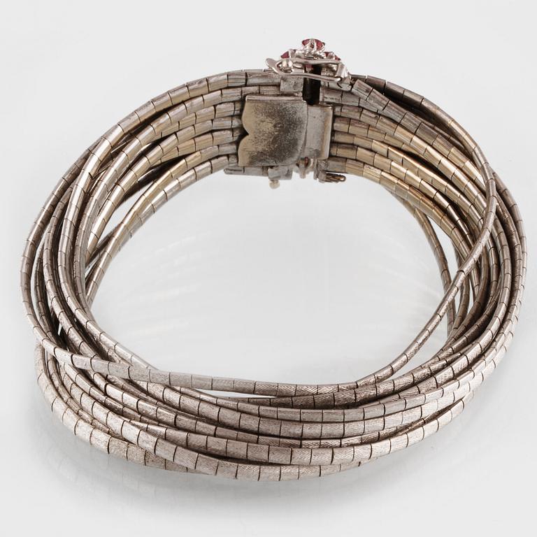 ARMBAND, 18K vitguld med 16 fasettslipade rubiner, troligtvis Italien. Vikt 96,5 gram.