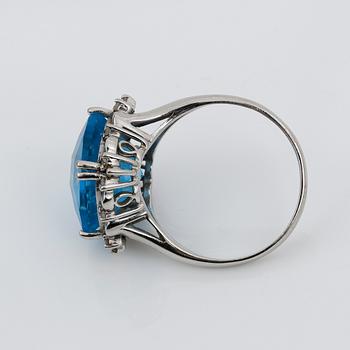 RING, 14K vitguld med blå checkerslipad topas tot ca 2.77 ct omges av små åttkantslipade diamanter. Vikt 4.56 g.