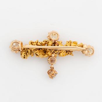 A gold brooch set with old-cut diamonds and an uncut diamond.