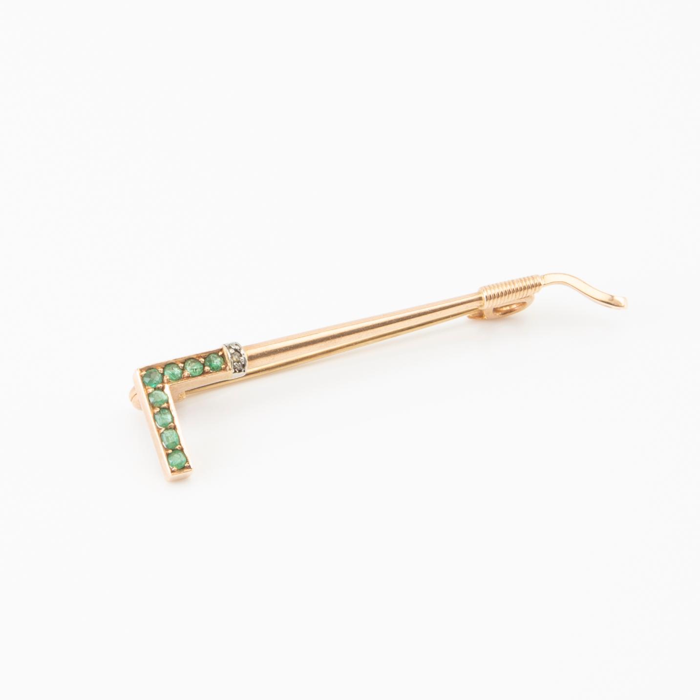 Brooch in the shape of a riding crop, 8K gold with faceted emeralds and ...