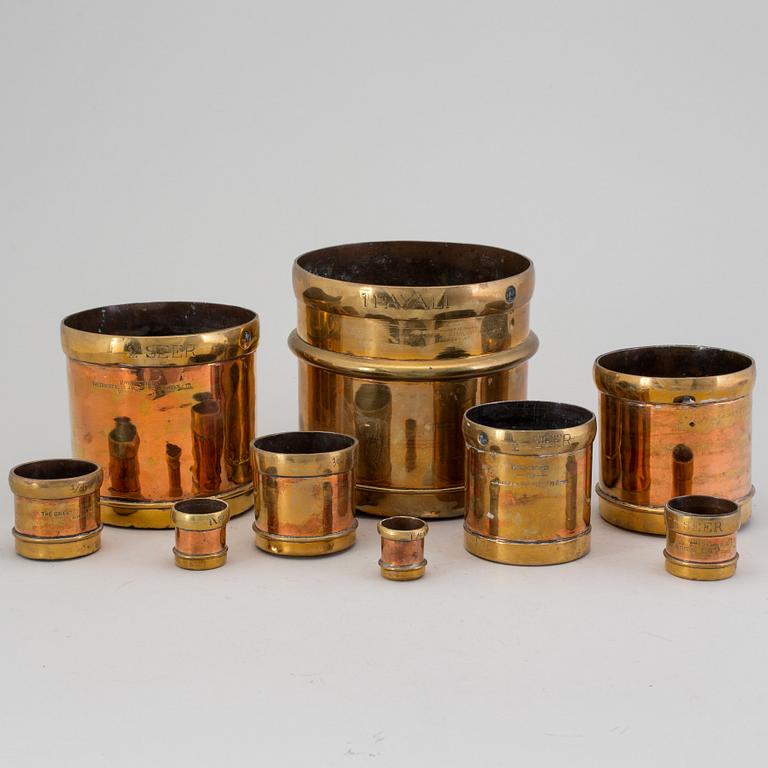 A set of nine brass measures, The Oriental Metal Pressing Works, Ltd, Bombay, Indien, 20th Century.