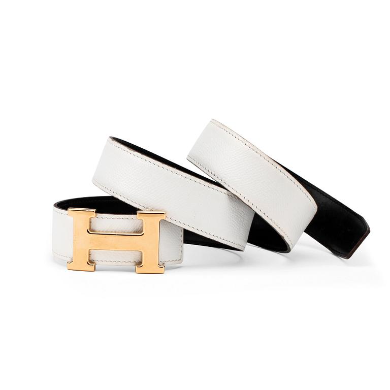 HERMÈS, a reversible belt, white and black with gold colored H belt buckle.
