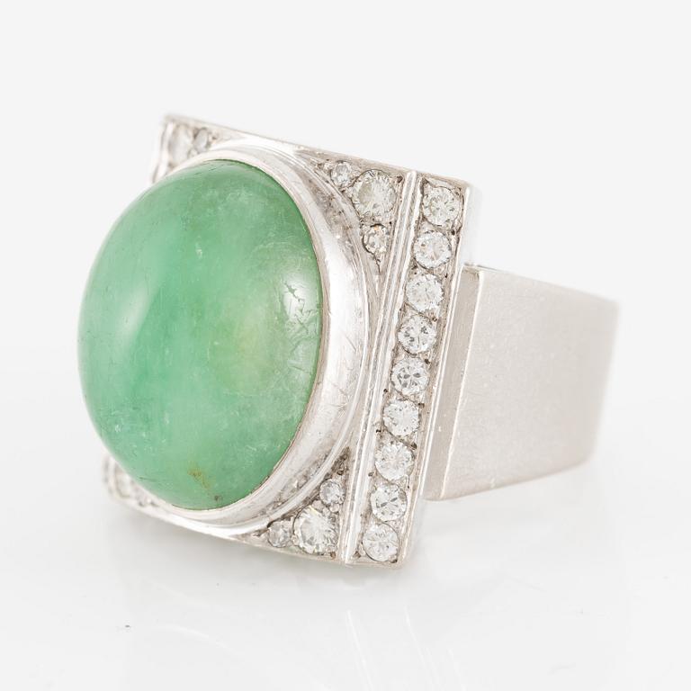 An 18K white gold ring set with a cabochon-cut emerald and round- and eight-cut diamonds.