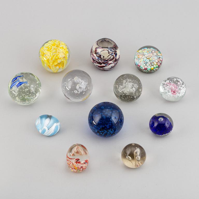 A group of 12 glass paper weights.
