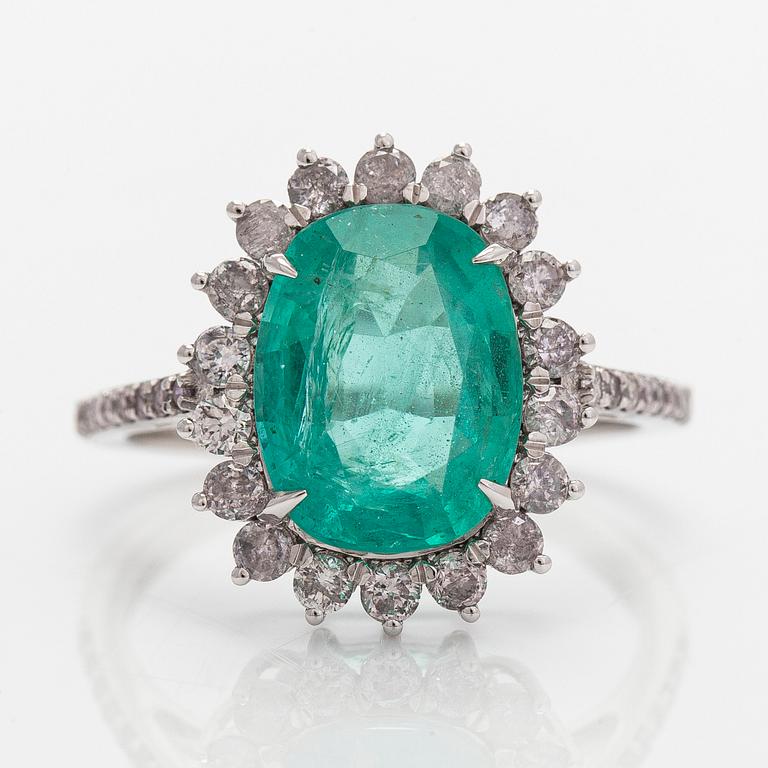 A 14K white gold ring, with an oval-cut emerald and diamonds. With IGI certificate.