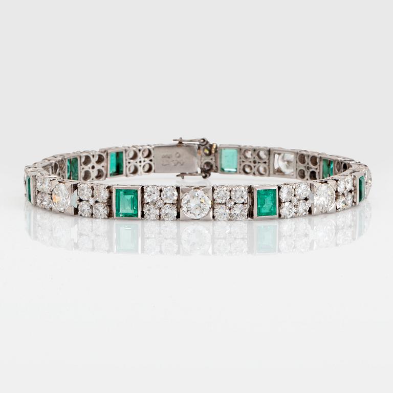 A platinum bracelet set with round brilliant- and old-cut diamonds and faceted emeralds.