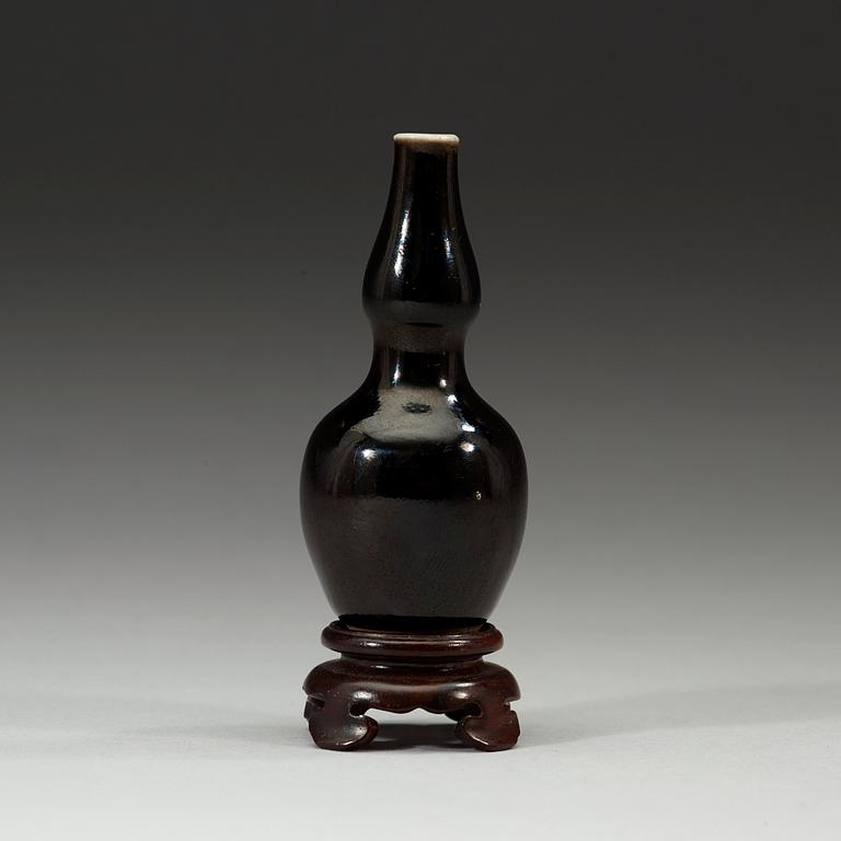 A black-glazed double gourd vase, Qing dynasty, 19th century.