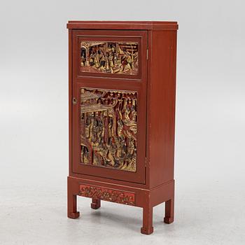A Chinese cabinet, early 20th Century, with 19th Century carved panels.