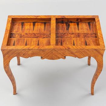 An elm veneered Rococo games table, 18th Century.