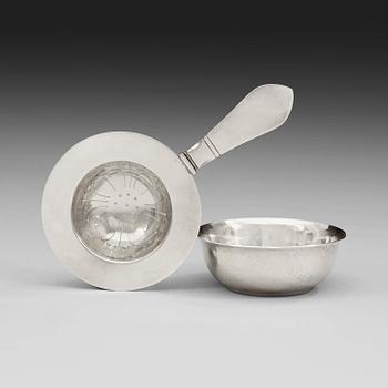 565. A Georg Jensen sterling tea strainer with its bowl, Copenhagen 1920's and 1933-44.