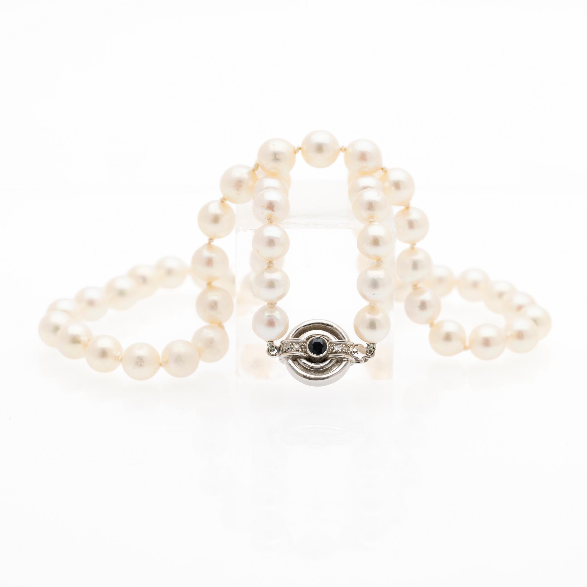 Pearl necklace, white gold clasp set with diamonds and a sapphire.