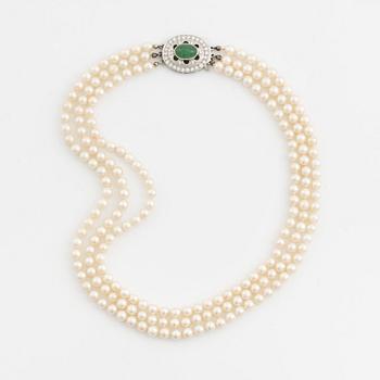 Three-row pearl necklace with cultured pearls, clasp with cabochon-cut emerald and brilliant-cut diamonds.