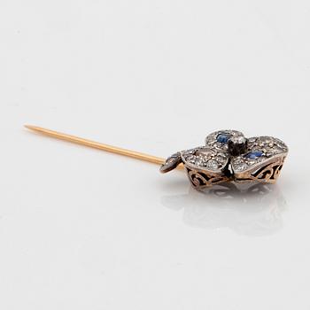 A four-leaf diamond and sapphire stick pin in platinum and 14K gold.