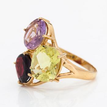 An 18K gold ring, with a garnet, citrine, and an amethyst.