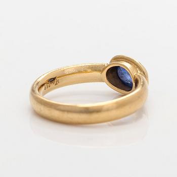 An 18K gold ring with a cabochon-cut sapphire.