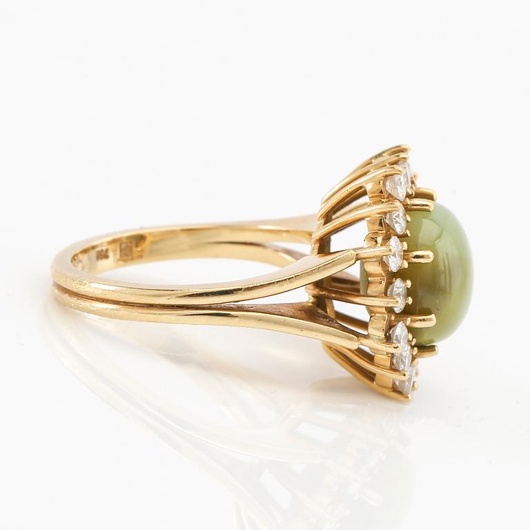 Ring 18K guld med cabochonslipad chrysoberyl med kattöga samt runda briljantslipade diamanter.