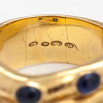 An 18K gold ring with rubies and sapphires. Import marked Torbjörn Tillander, Helsinki 1991.