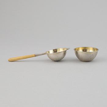 A silver and wood tea strainer by Wiwen Nilsson, Lund, 1932.