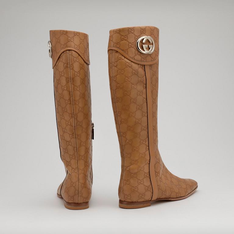 GUCCI, a pair of beige monogram leather boots.