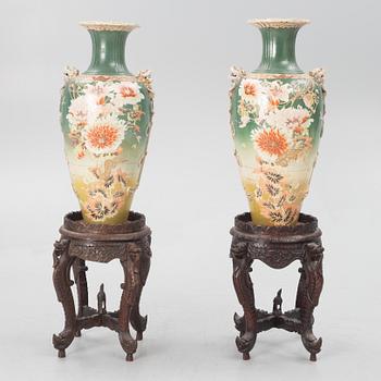 A pair of Japanese porcelain urns, first half of the 20th century, with pedestals.
