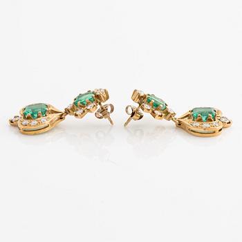 A pair of 18K gold earrings with faceted emeralds and round brilliant-cut diamonds.