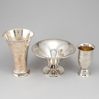Two silver beakers and a bowl.