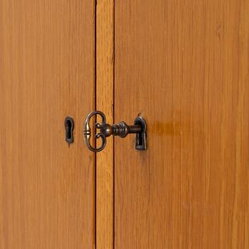 An oak veneered cabinet. 20th Century.
