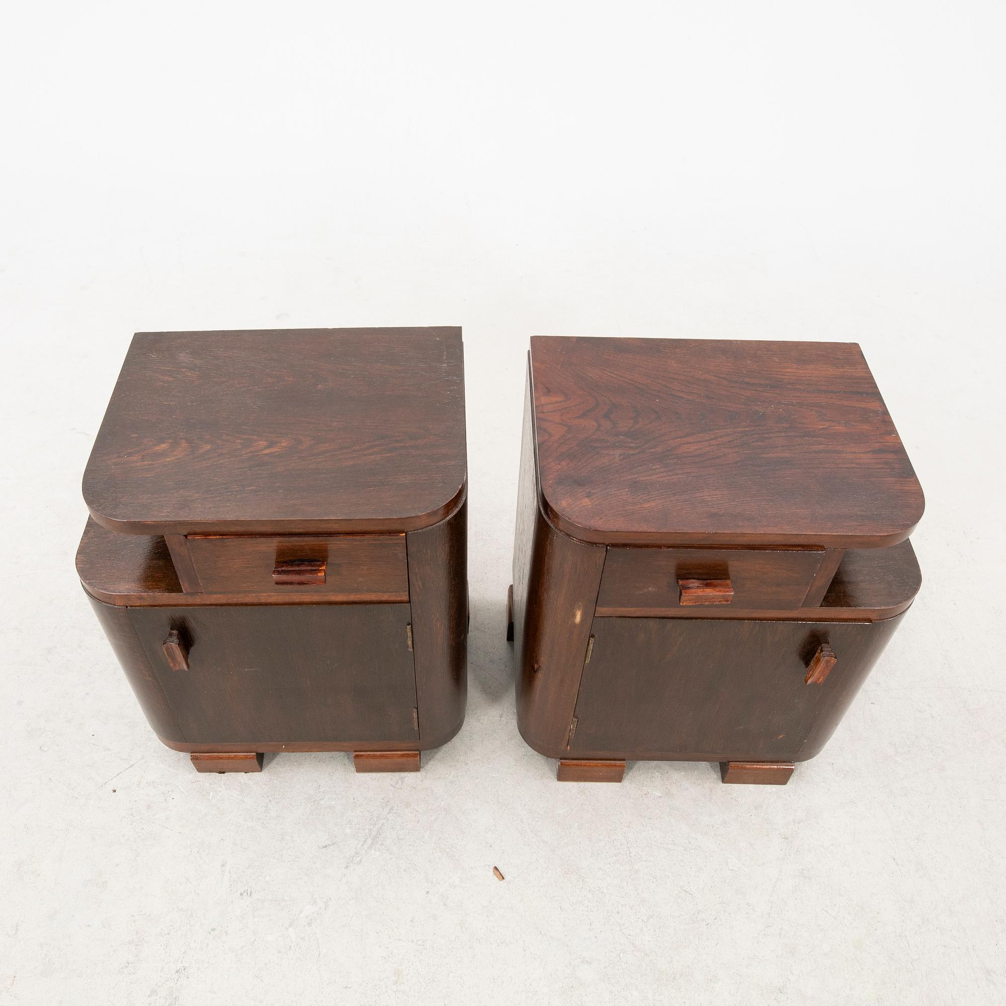 A pair of stained wood bedside tables from the first half of the 20th century.