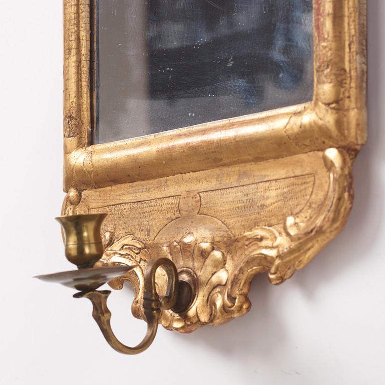 A matched pair of rococo giltwood one-light girandoles, later part of the 18th century.