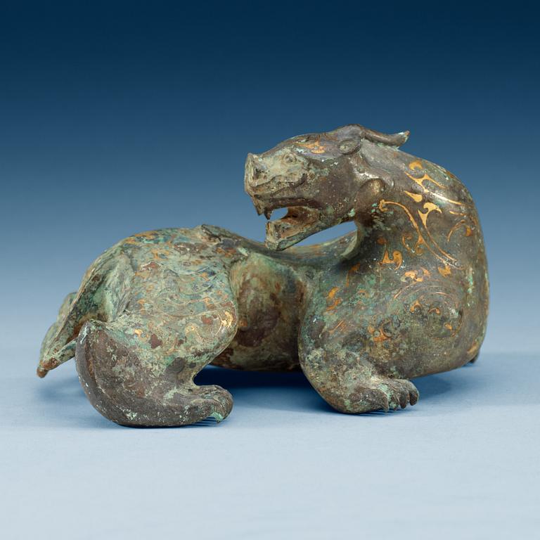 An archaistic bronze figure of a mythological beast.