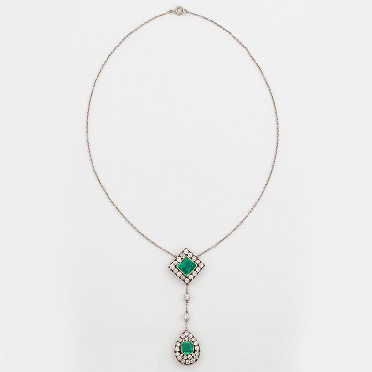 A necklace set with two faceted emeralds and old-cut diamonds.