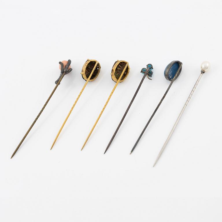 Six brooch pins in various designs and materials.