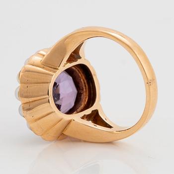 An 18K gold ring set with a faceted amethyst and pearls.