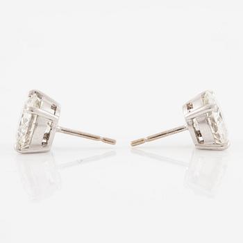 A pair of earrings in 18K white gold set with two round brilliant-cut diamonds.