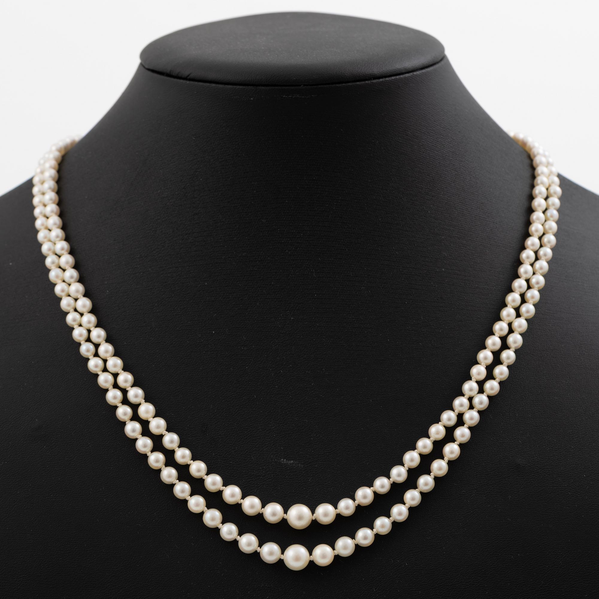 Double-row necklace with graduated cultured pearls, silver clasp set with paste stones.